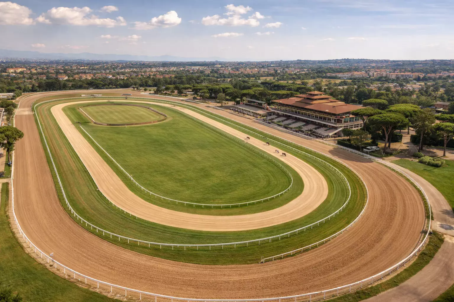 Ippodromo italiano con tribune e pista vista dall'alto durante una riunione di corse